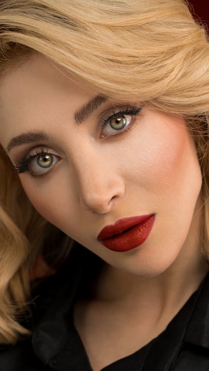 Woman wearing full makeup including foundation, blush, bronzer, and dark eyeshadow — natural coloring is obscured